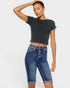 Woman wearing a dark gray cropped t-shirt and blue denim shorts on a white background