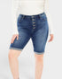 Person wearing blue denim shorts with button details on a white background