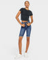 Person wearing a black t-shirt and blue denim shorts on a white background