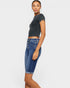 Woman wearing a dark gray cropped t-shirt and blue denim shorts on a white background