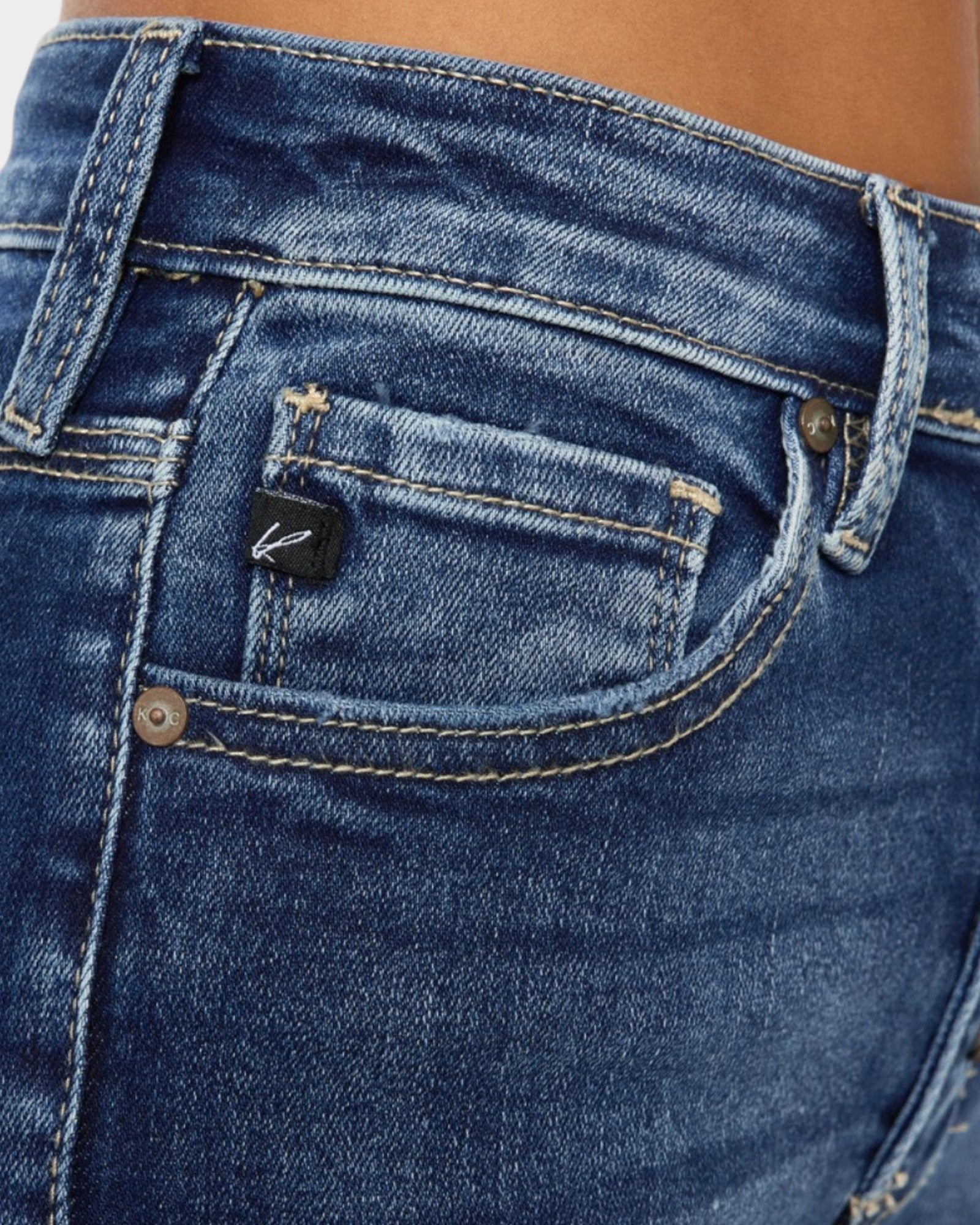 Close-up of blue jeans with a brand logo on the pocket.