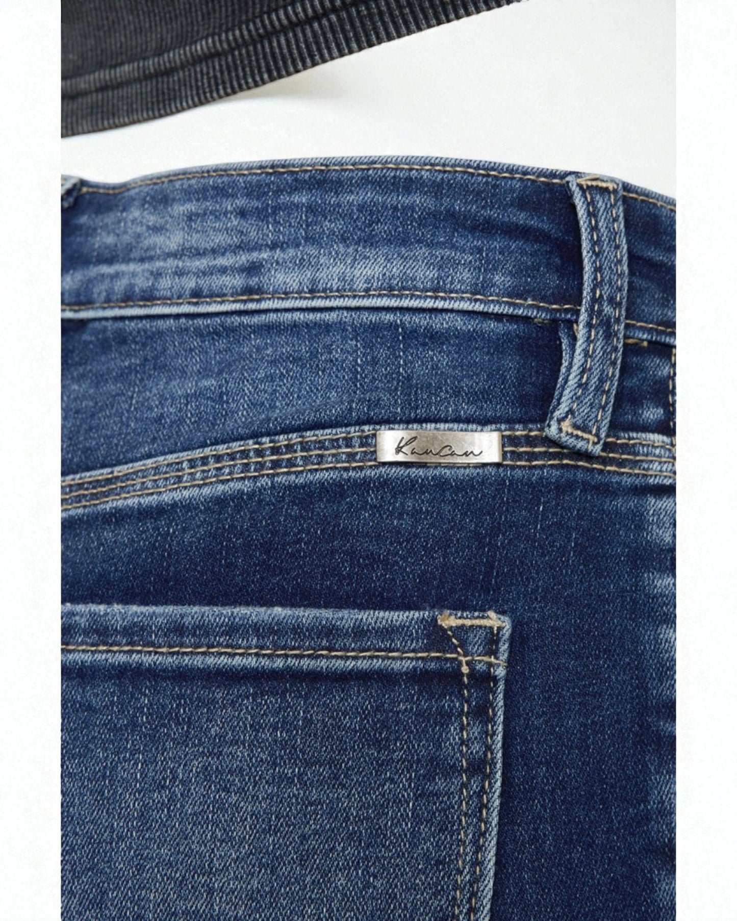 Close-up of blue jeans with a brand label on a white background