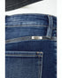 Close-up of blue jeans with a brand label on a white background