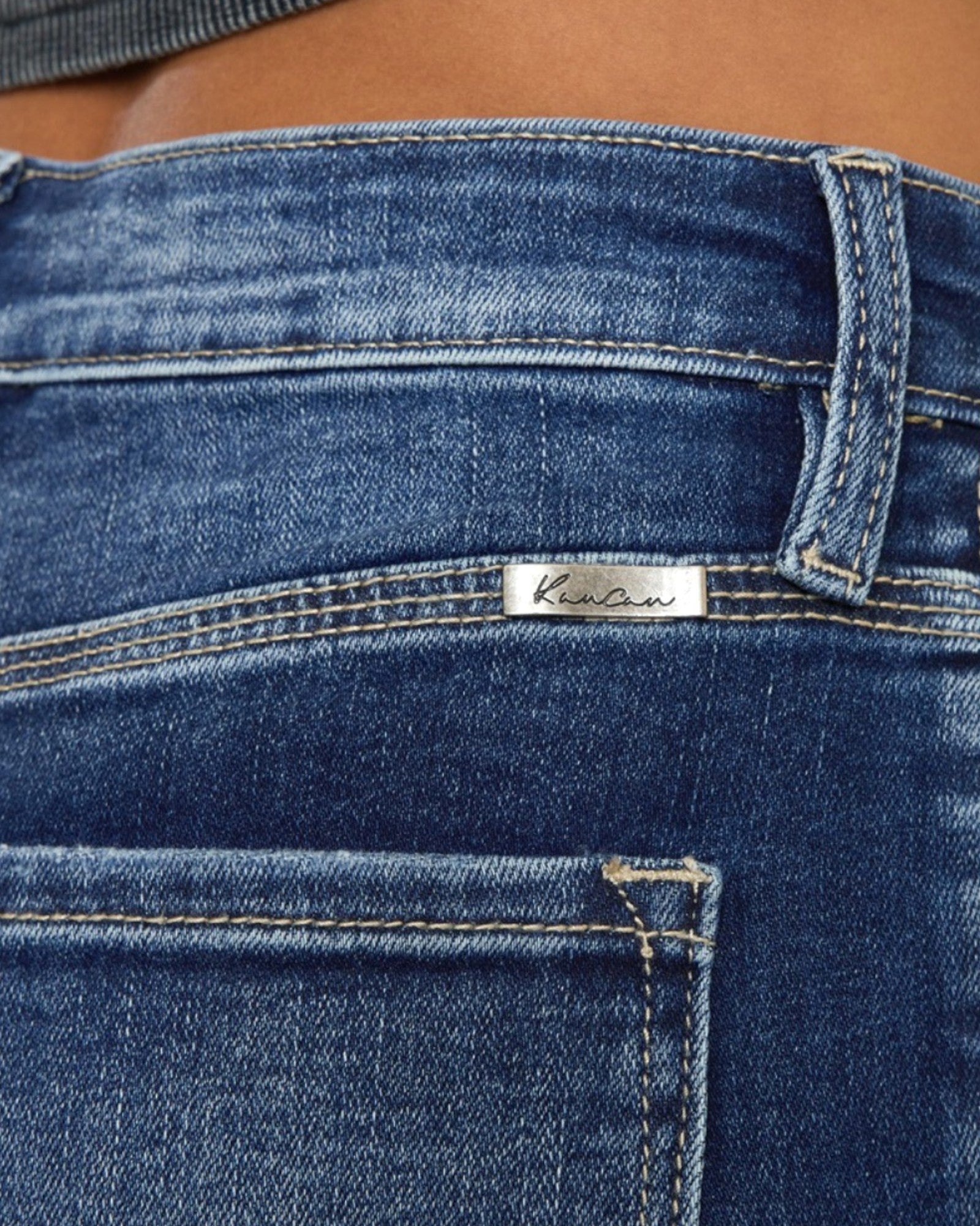 Close-up of blue jeans with a brand label on the waistband.