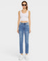 Woman wearing a white tank top and blue jeans on a white background