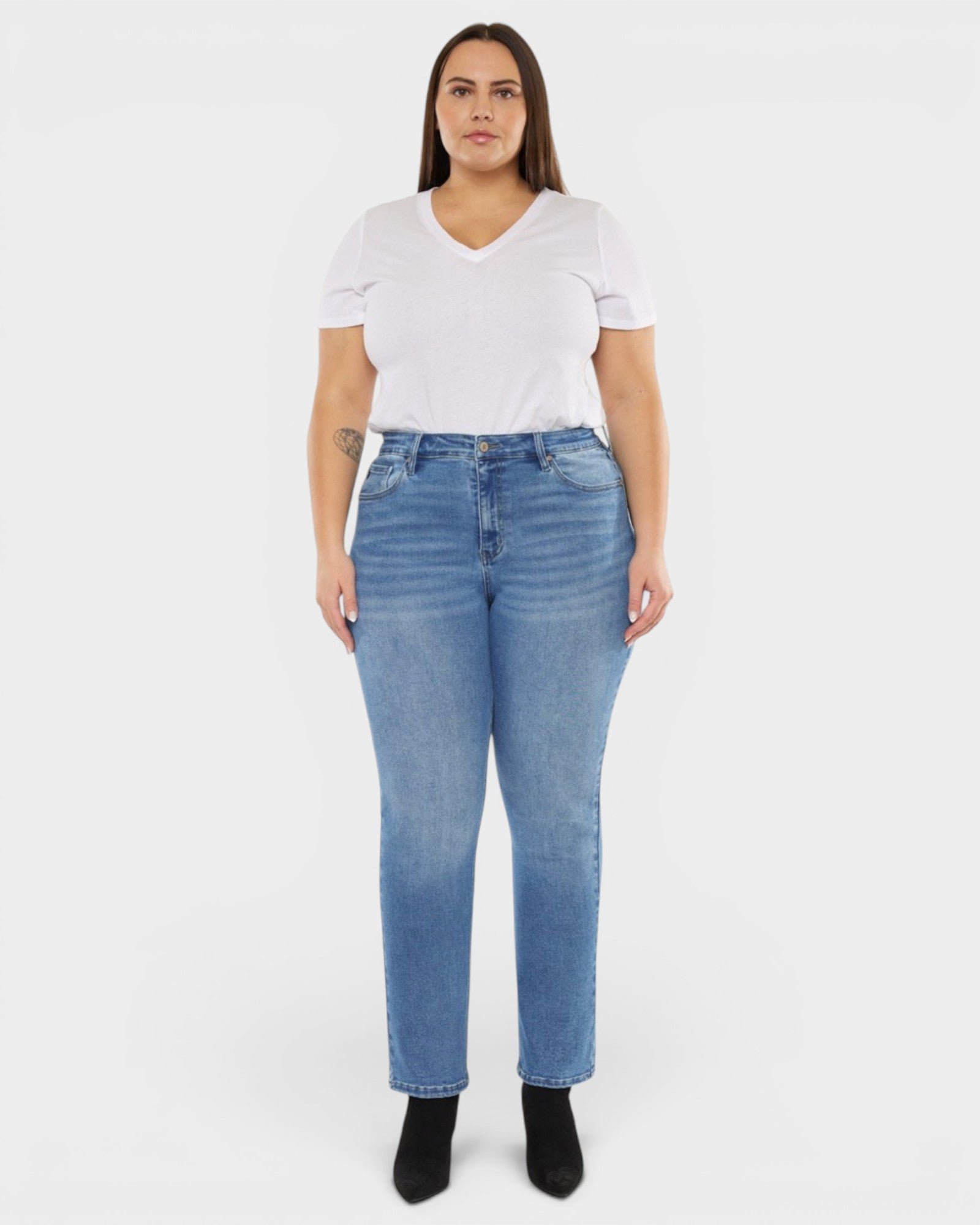 Woman wearing a white t-shirt and blue jeans on a white background
