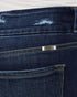 Close-up of dark blue jeans with a brand logo on the back pocket.