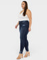 Woman wearing dark blue jeans and a white top on a white background