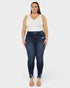 Woman wearing dark blue jeans and a white top on a white background