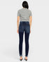 Person wearing dark blue jeans and a gray top on a white background