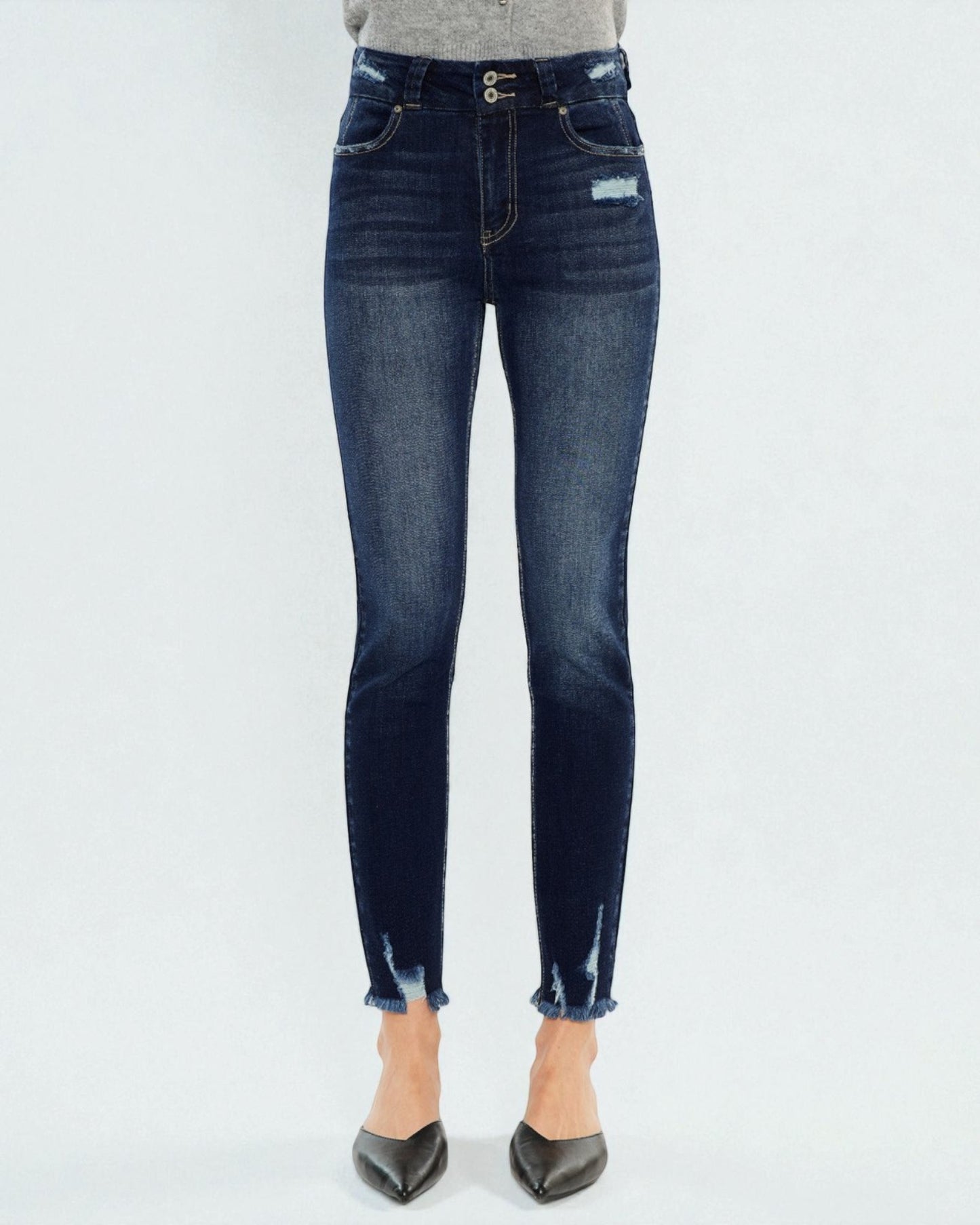 Dark blue jeans worn by a person on a white background