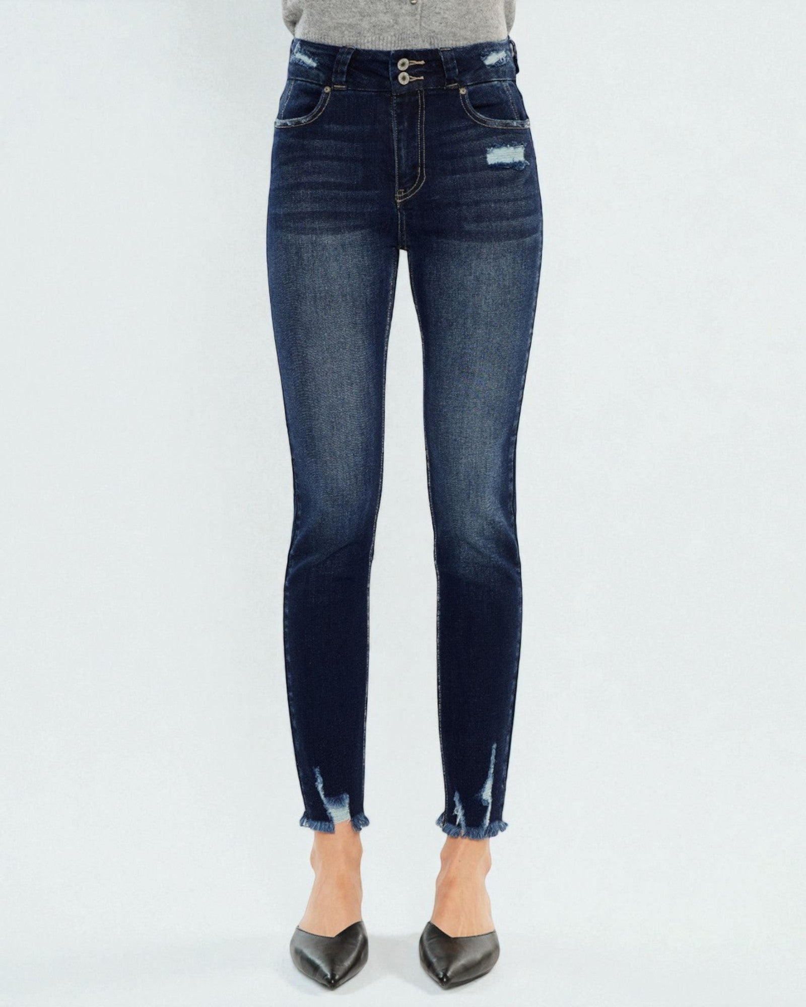 Dark blue jeans worn by a person on a white background