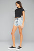 Woman wearing a black t-shirt and denim shorts on a gray background