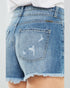 Close-up of a person wearing blue denim shorts with a white background