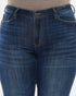 Close-up of a person wearing dark blue denim jeans with a ribbed beige top visible at the waistband.