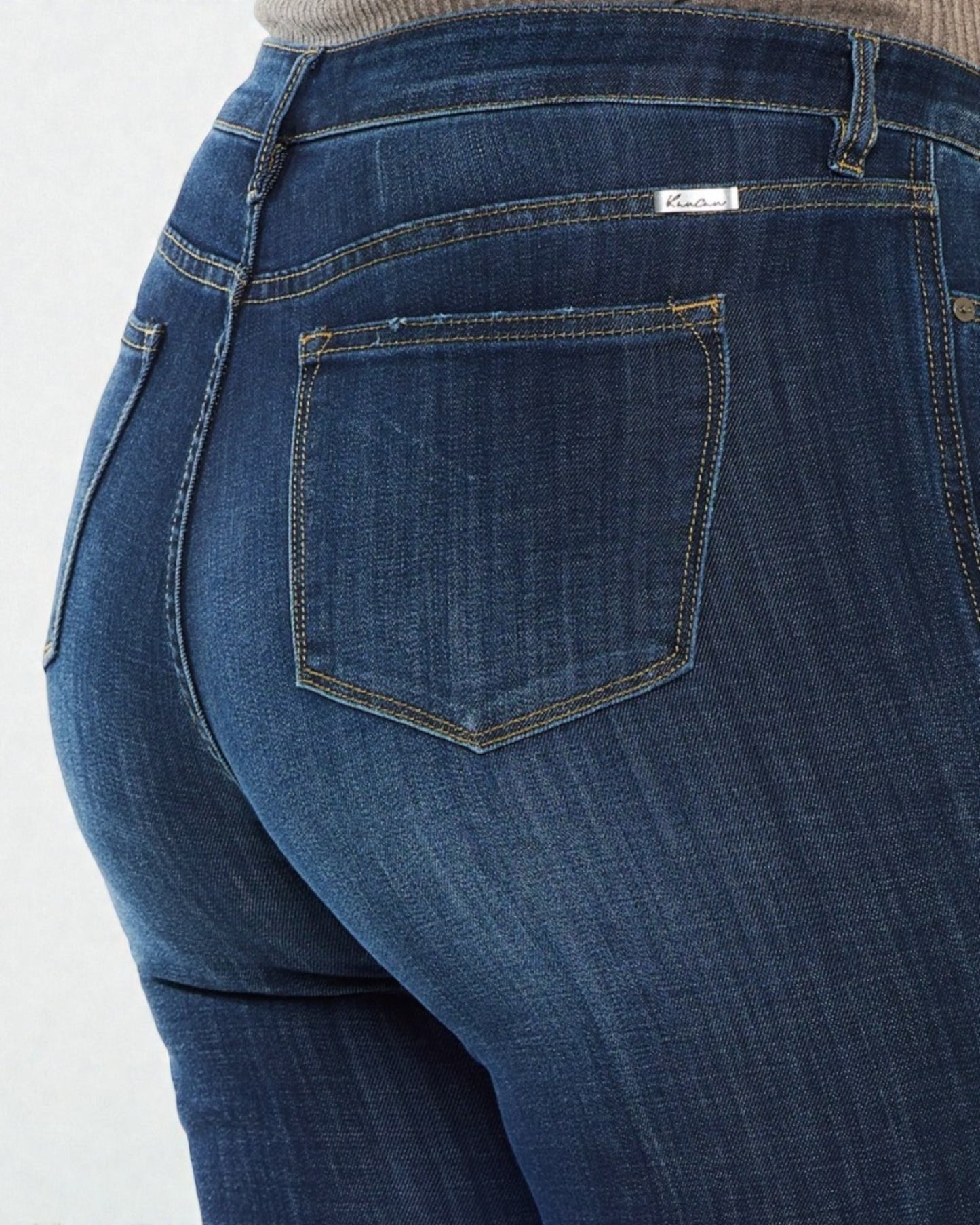 Close-up of blue jeans with a visible brand label on a white background