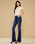 Woman wearing a white top and blue jeans against a beige background