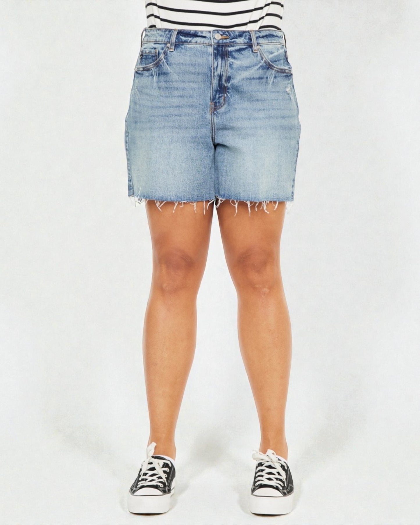 Person wearing light blue denim shorts on a white background