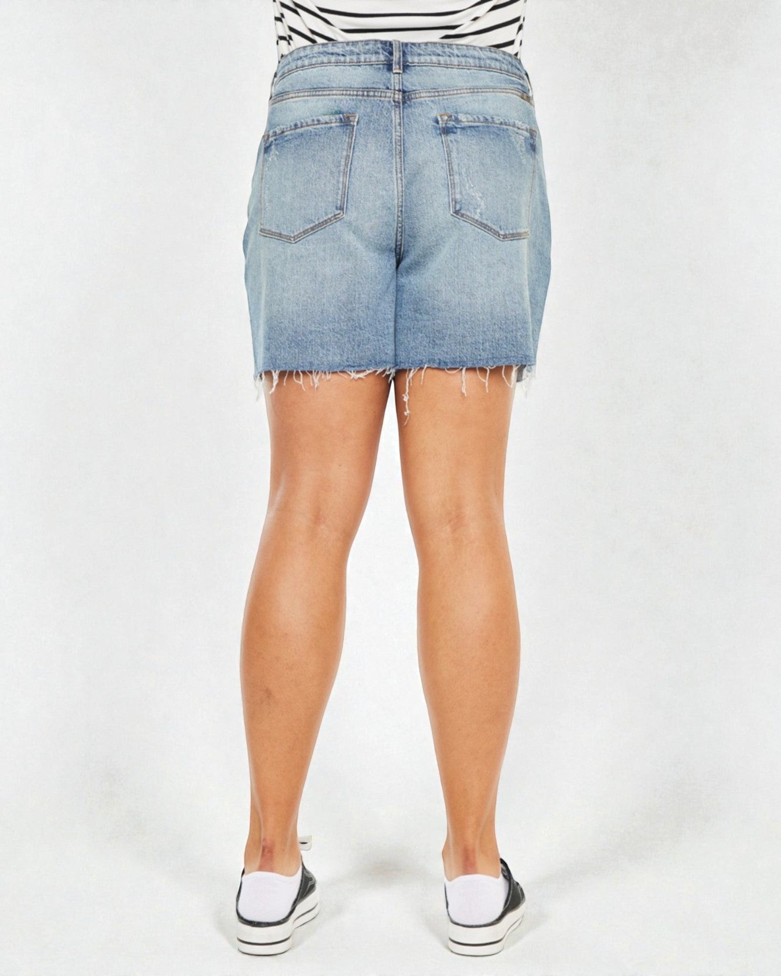 Denim shorts worn by a person on a white background