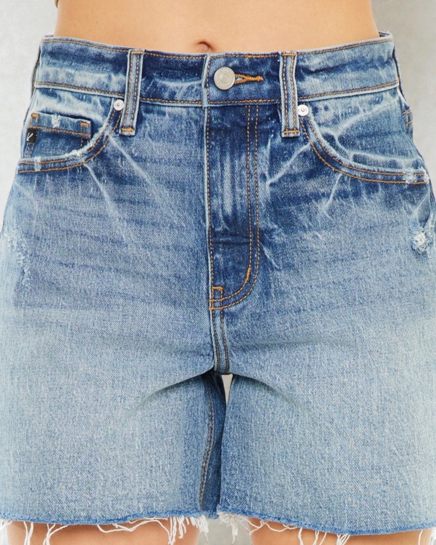 Close-up of blue denim shorts with a plain background