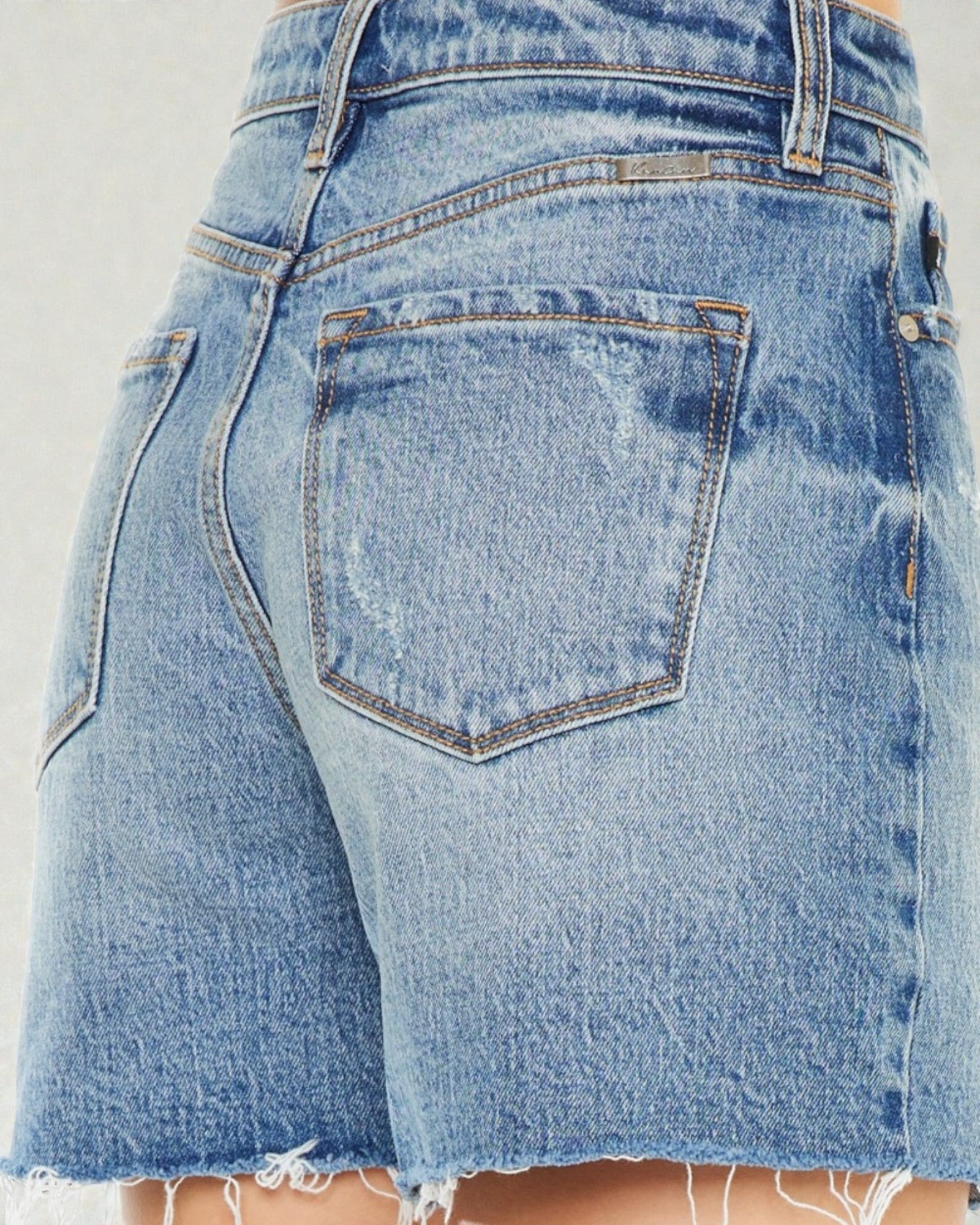 Close-up of a pair of blue denim shorts with a white background