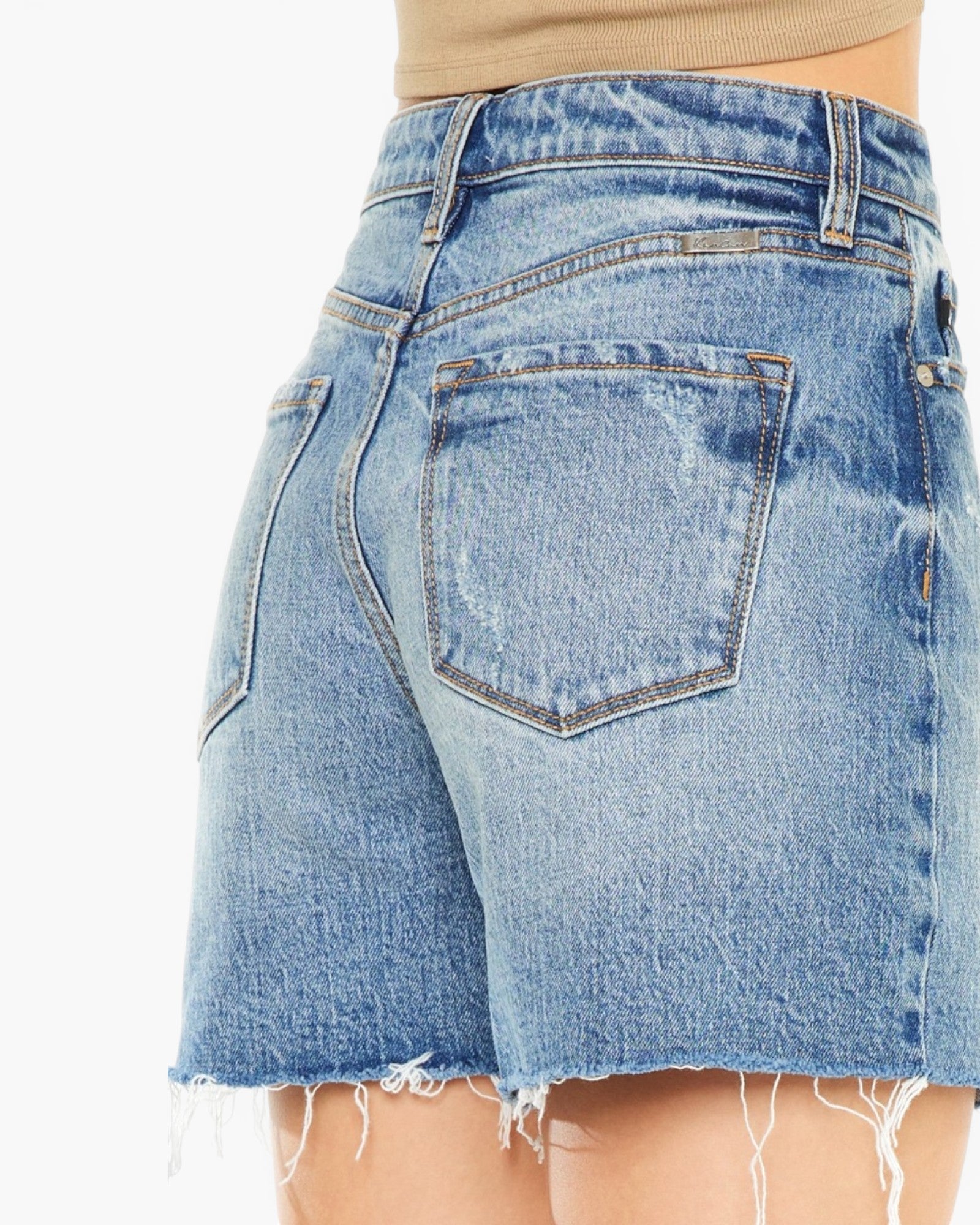 Close-up back view of light blue denim shorts with a frayed hem, shown on a model against a plain white background.
