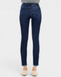 Dark blue jeans worn by a person on a white background