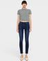 Woman wearing dark blue jeans and a gray cropped top on a white background