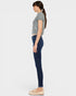 Woman wearing a gray sleeveless top and dark blue jeans on a white background