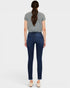 Woman wearing blue jeans and a gray top on a white background