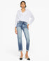 A model wearing a white long-sleeve button-up shirt and light-wash blue cropped jeans with rolled cuffs, paired with black and beige pointed-toe heels, against a plain white studio background.