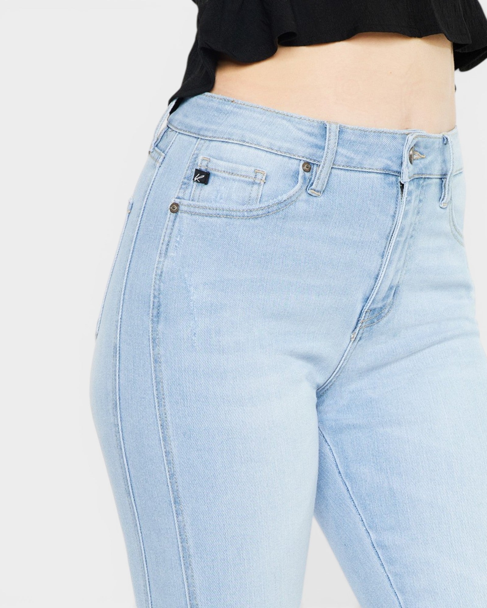 Light blue jeans worn by a person on a plain background