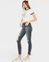 Woman wearing a white t-shirt and gray distressed jeans on a white background