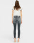 Person wearing a white t-shirt with black trim and dark jeans on a white background