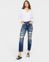 Woman wearing a white shirt and blue ripped jeans on a white background