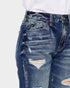Close-up of distressed blue jeans on a white background