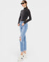 Woman wearing a black turtleneck and light blue jeans on a white background