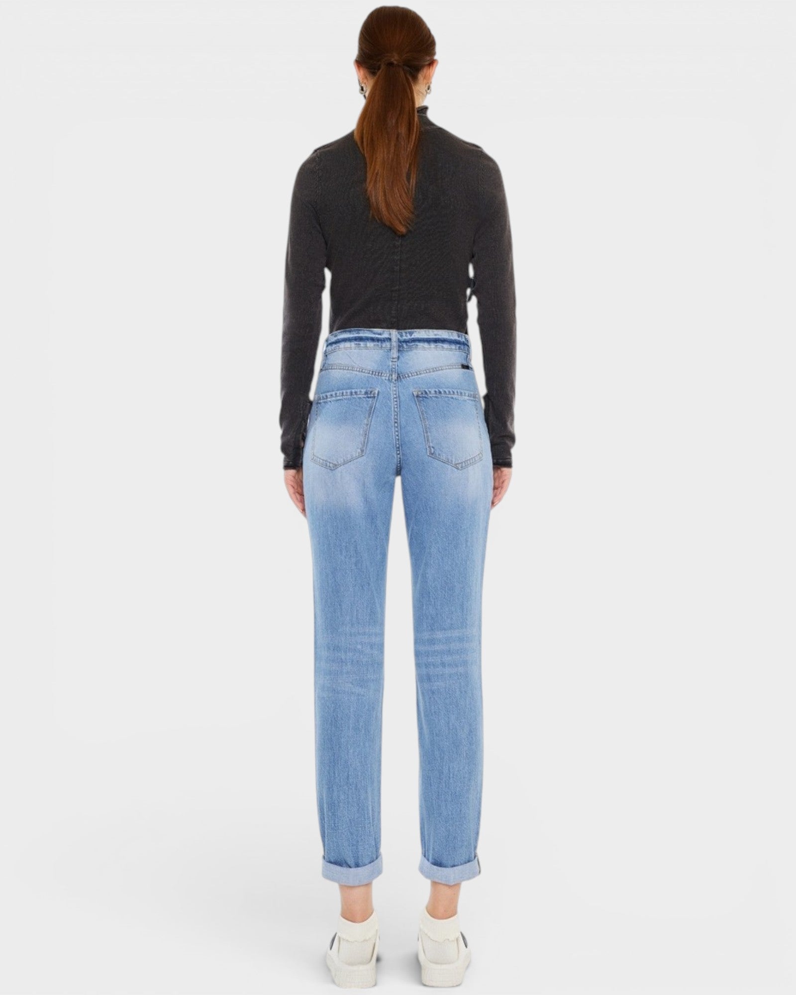 Person wearing light blue jeans on a white background