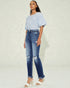 Woman wearing a striped top and blue jeans on a light background
