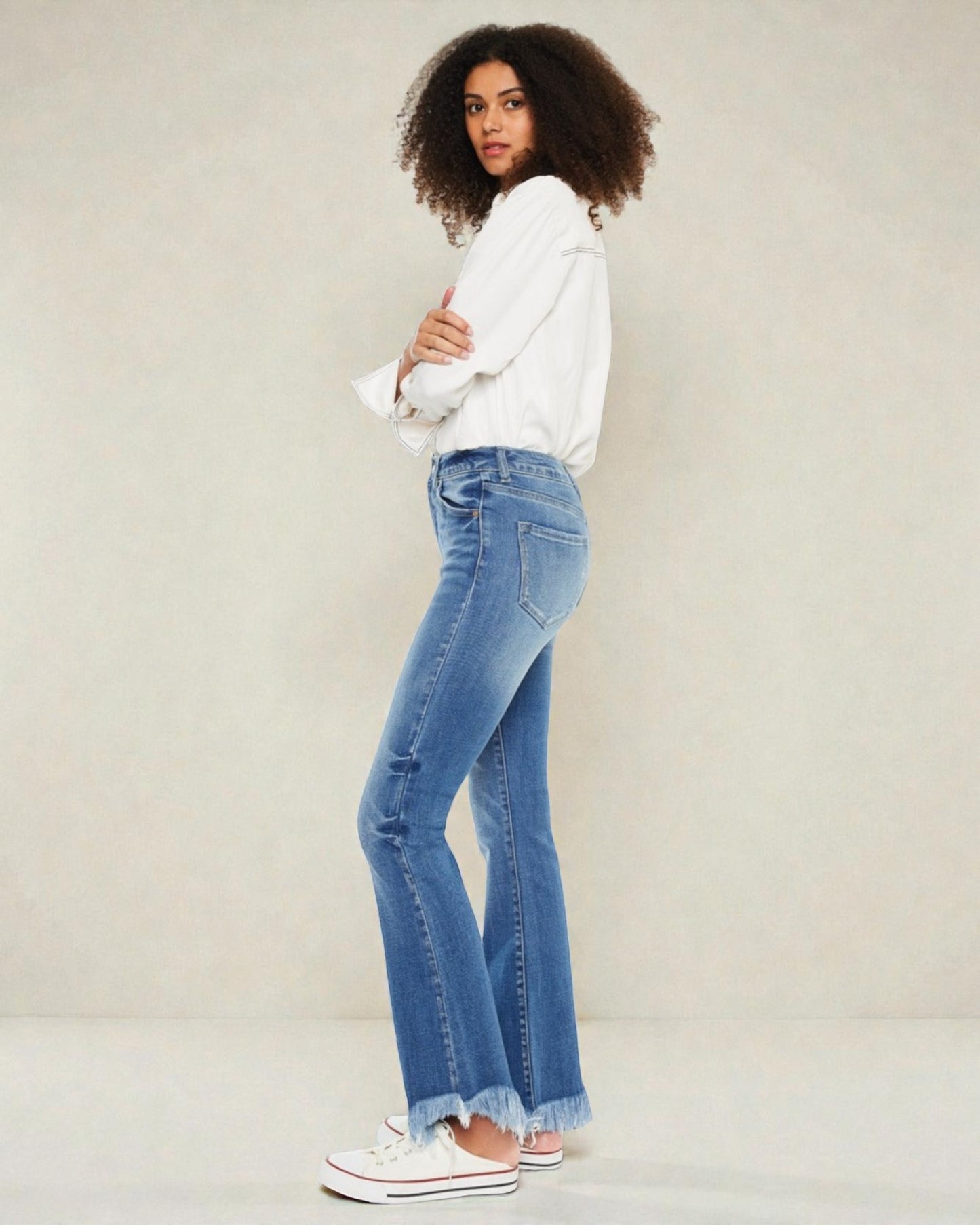 Person wearing blue jeans and a white shirt against a plain background