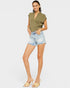 Woman wearing a green top and denim shorts on a white background