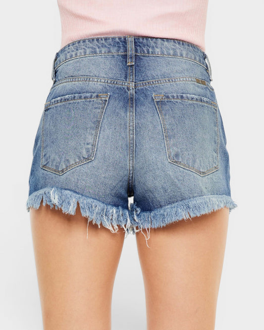 Denim shorts with frayed hem on a plain background