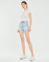 Woman wearing light blue denim shorts and a white t-shirt on a white background