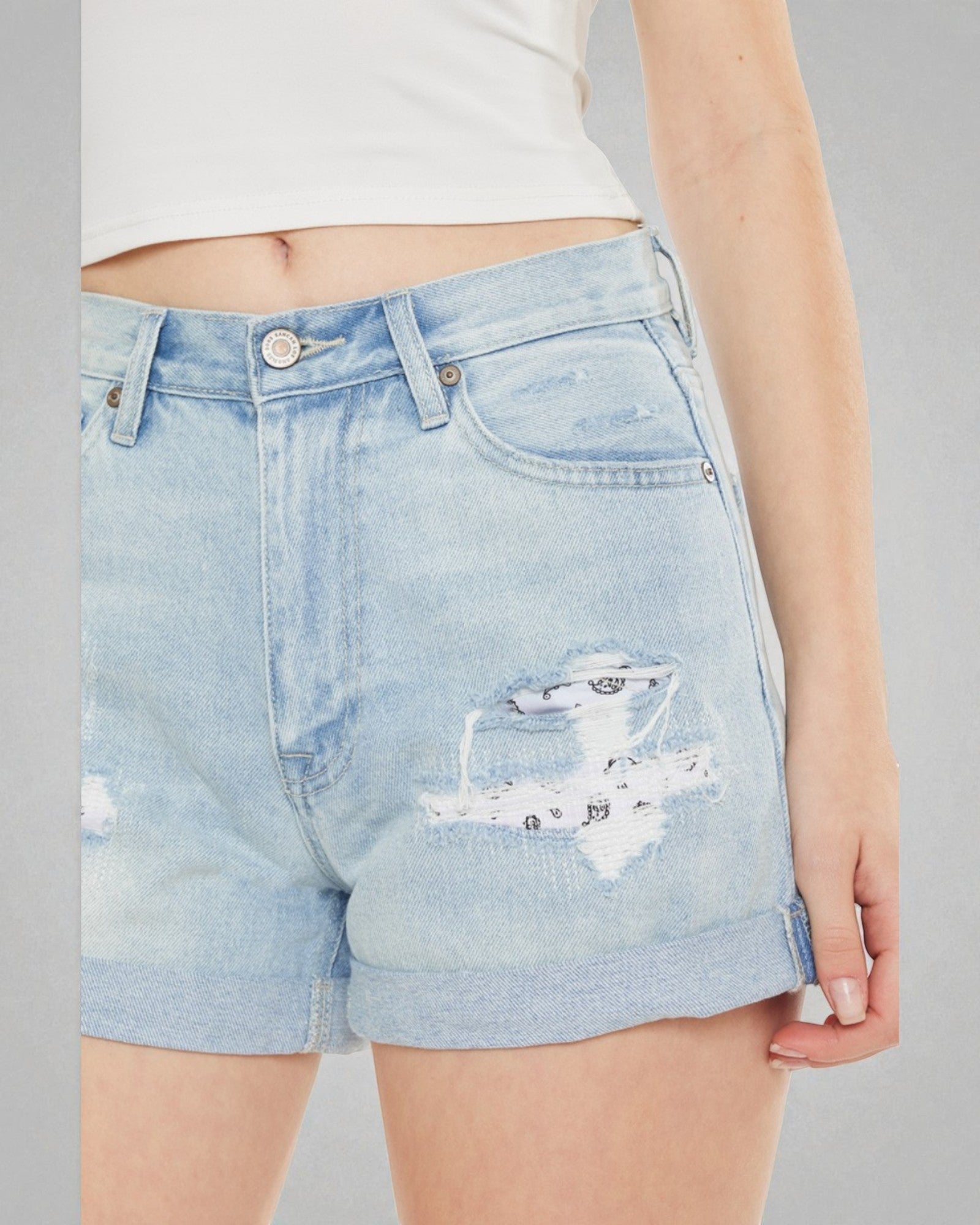 Light blue denim shorts with a subtle pattern on a gray background