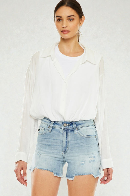 Woman wearing a white blouse and light blue denim shorts on a white background