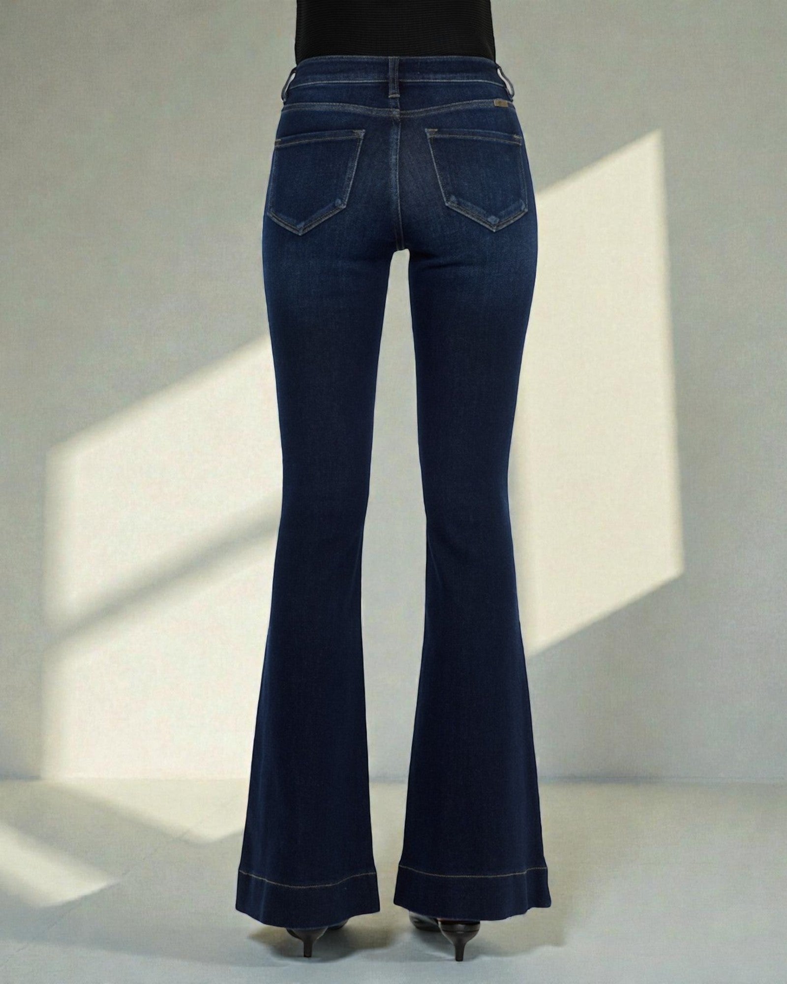 Dark blue flared jeans on a plain background
