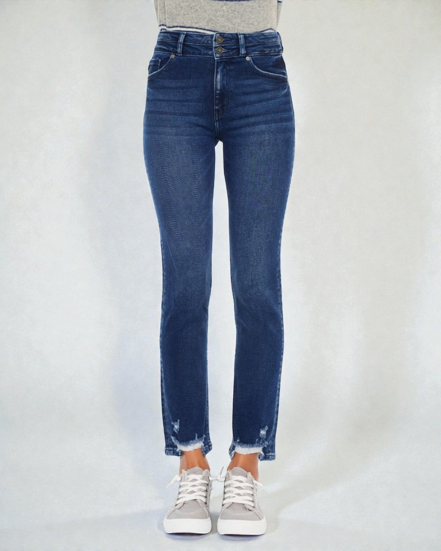 Blue jeans worn by a person on a plain background