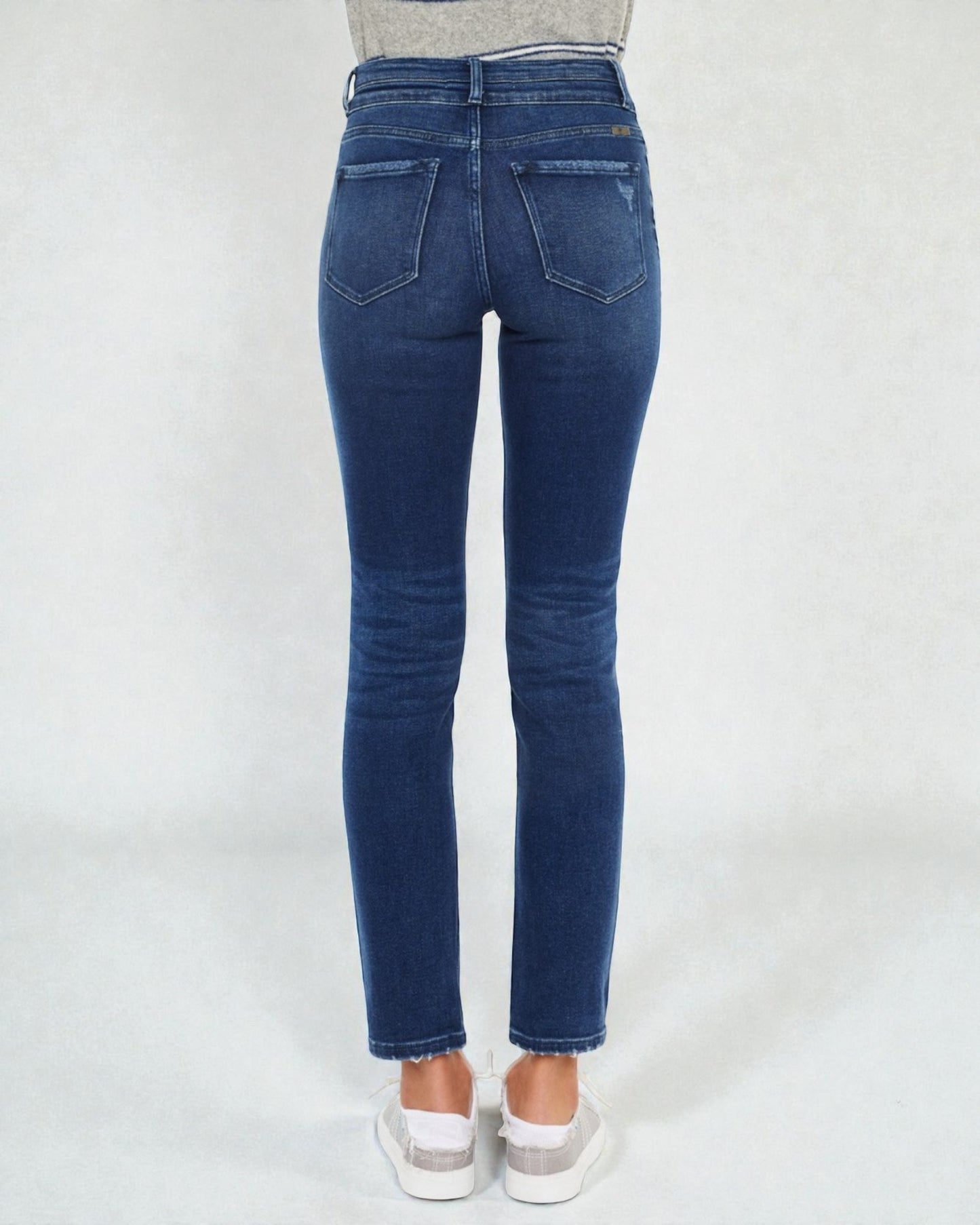 Blue jeans worn by a person on a white background