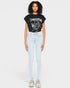 Woman wearing a black t-shirt with graphic design and light blue jeans on a white background