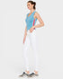 Woman wearing a blue sleeveless top with red stripes and white pants on a light gray background
